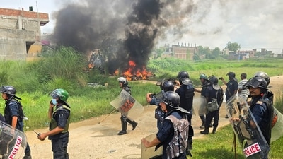 Members of Nepal Police stand next to burnt motorbikes as they wait for a fire engine during a clash between two communities in Siraha, Nepal. (REUTERS)