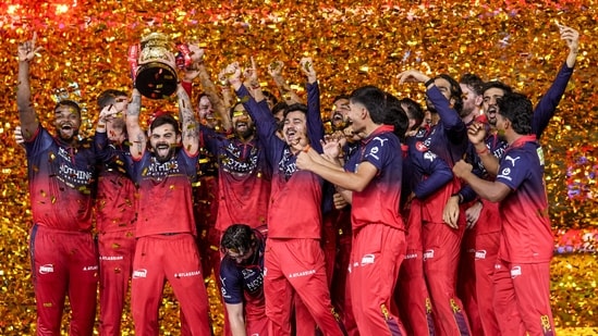 Royal Challengers Bengaluru's players celebrate with the tournament trophy during the presentation ceremony after winning the Indian Premier League (IPL) 2026 title, in Ahmedabad. 
