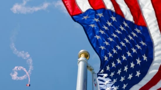 Members of the US Army parachute team 'Golden Knights' perform above a US flag during the 'Salute to America' Independence Day celebration on the National Mall in Washington, DC, on July 4, 2026.(AFP)
