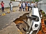 A car in a sinkhole at Gurdev Chowk after the carriageway caved in during rain in Ludhiana on Thursday morning. The driver had a narrow escape and the car was later pulled out using a crane. (Gurpret Singh/HT)