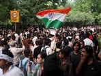 A supporter of Cockroach Janata Party (CJP) holds an Indian national flag at the protest site at Jantar Mantar in New Delhi.