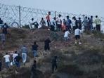 People gather on a hilltop near Bab Sebta on the Morocco-Spain border, near Spain's enclave of Ceuta and the Moroccan town of Fnideq on July 30, 2026. (Photo by Abdelmajid BZIOUAT / AFP)
