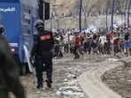 Moroccan security forces clash with migrants attempting to cross into Spain's North African enclave of Ceuta near the town of Fnideq, on the Morocco-Spain border, on July 31.