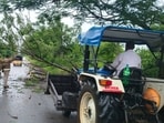 Police personnel help to clear the site of a tree collapse due to heavy rainfall in Jagtial district on Thursday. (HT PHOTO)
