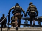 Immigration and Customs Enforcement (ICE) agents walk outside the Ventura County Government Center in Ventura, California, on July 27, 2026. The Ventura County Government Center has been the site of tense standoffs and confrontations in recent weeks between US Immigration and Customs Enforcement (ICE) agents, local community observers, and protesters. (Photo by Blake Fagan / AFP)