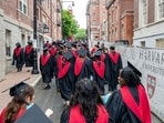Harvard University students walking through Harvard Square during commencement.