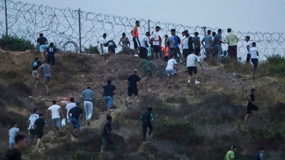 People gather on a hilltop near Bab Sebta on the Morocco-Spain border, near Spain's enclave of Ceuta and the Moroccan town of Fnideq on July 30, 2026. (Photo by Abdelmajid BZIOUAT / AFP) (AFP) People gather on a hilltop near Bab Sebta on the Morocco-Spain border, near Spain's enclave of Ceuta and the Moroccan town of Fnideq on July 30, 2026. (Photo by Abdelmajid BZIOUAT / AFP) (AFP)
