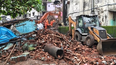 Mud, Debris and earthmoving machinery at the site as rescue personnel conduct rescue operations after a portion of the Kohinoor Building in Balaji Nagar area of the powerloom town collapsed. (PTI) Mud, Debris and earthmoving machinery at the site as rescue personnel conduct rescue operations after a portion of the Kohinoor Building in Balaji Nagar area of the powerloom town collapsed. (PTI)
