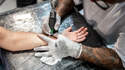 An artist working on a tattoo. An artist working on a tattoo.