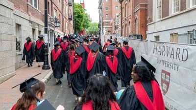 Harvard University students walking through Harvard Square during commencement. Harvard University students walking through Harvard Square during commencement.