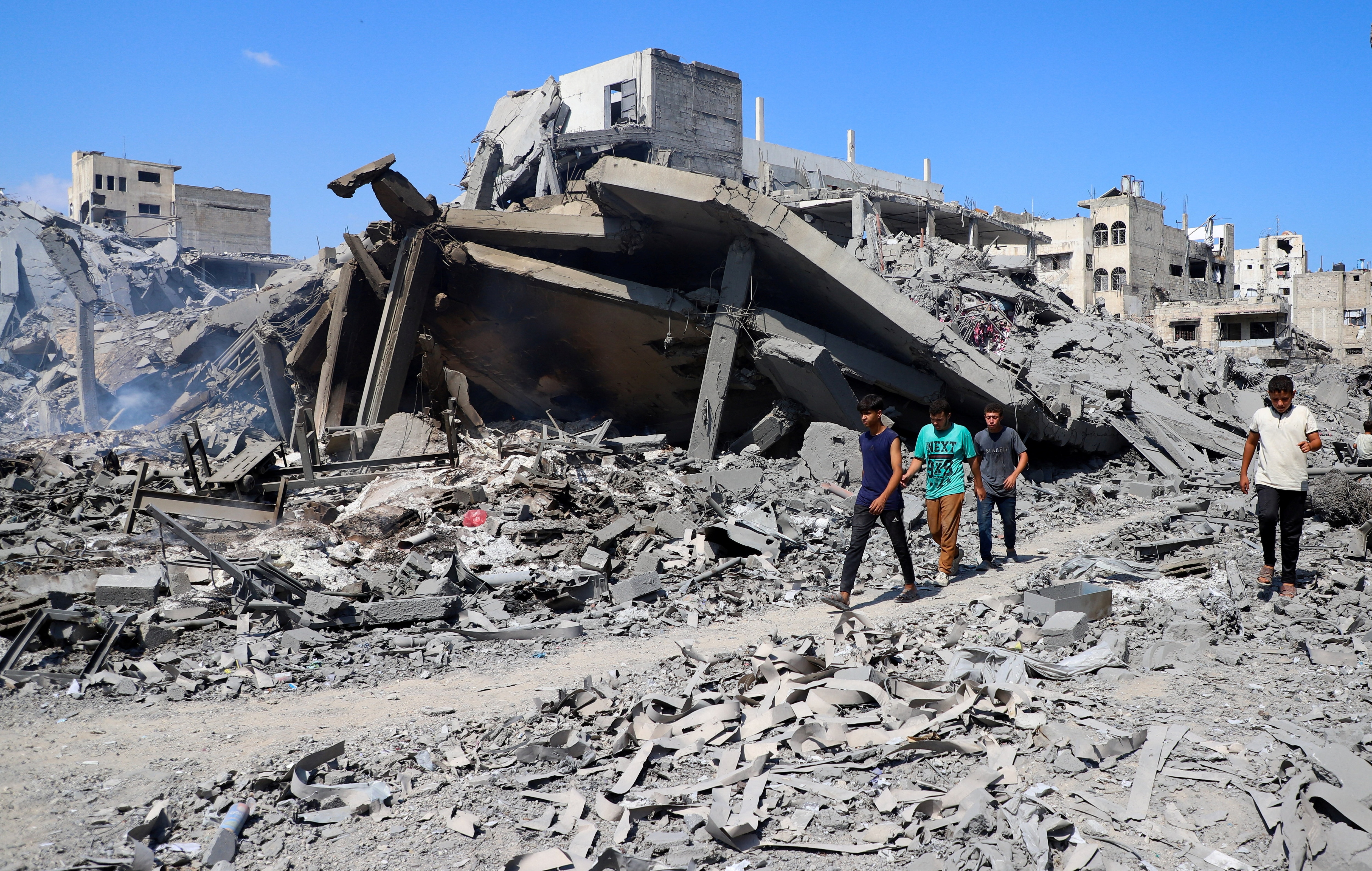 Palestinians inspect a site of an Israeli strike on a storage facility, that had been warned by the Israeli military to evacuate earlier on Sunday before it was struck later the same day, in Gaza City. (REUTERS)