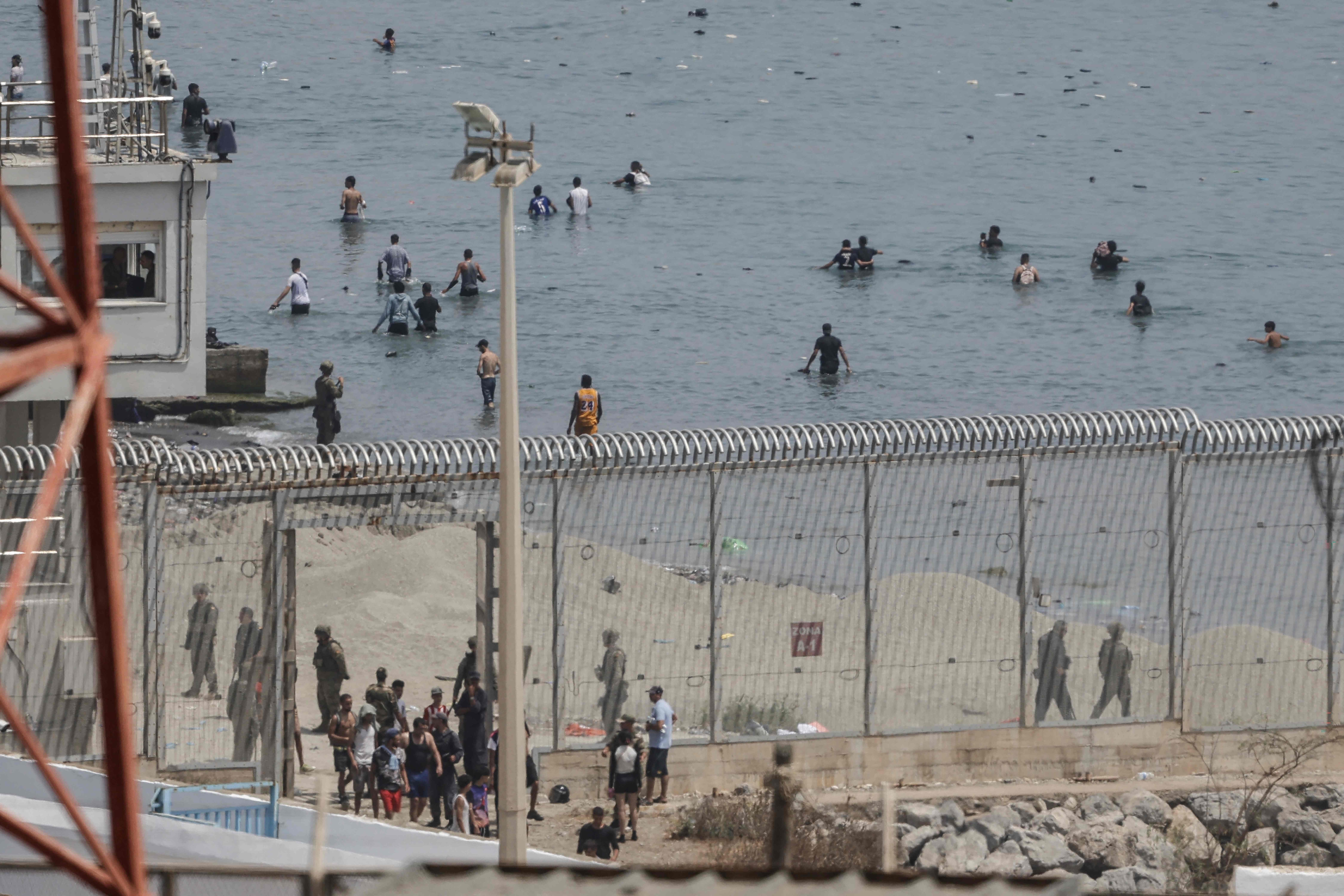 A photograph taken from the outskirts of the Moroccan town of Fnideq on the Morocco-Spain border shows Spanish Guardia Civil officers monitoring migrants attempting to reach Spain's North African enclave of Ceuta by swimming across the maritime border, on July 31, 2026. (AFP) A photograph taken from the outskirts of the Moroccan town of Fnideq on the Morocco-Spain border shows Spanish Guardia Civil officers monitoring migrants attempting to reach Spain's North African enclave of Ceuta by swimming across the maritime border, on July 31, 2026. (AFP)