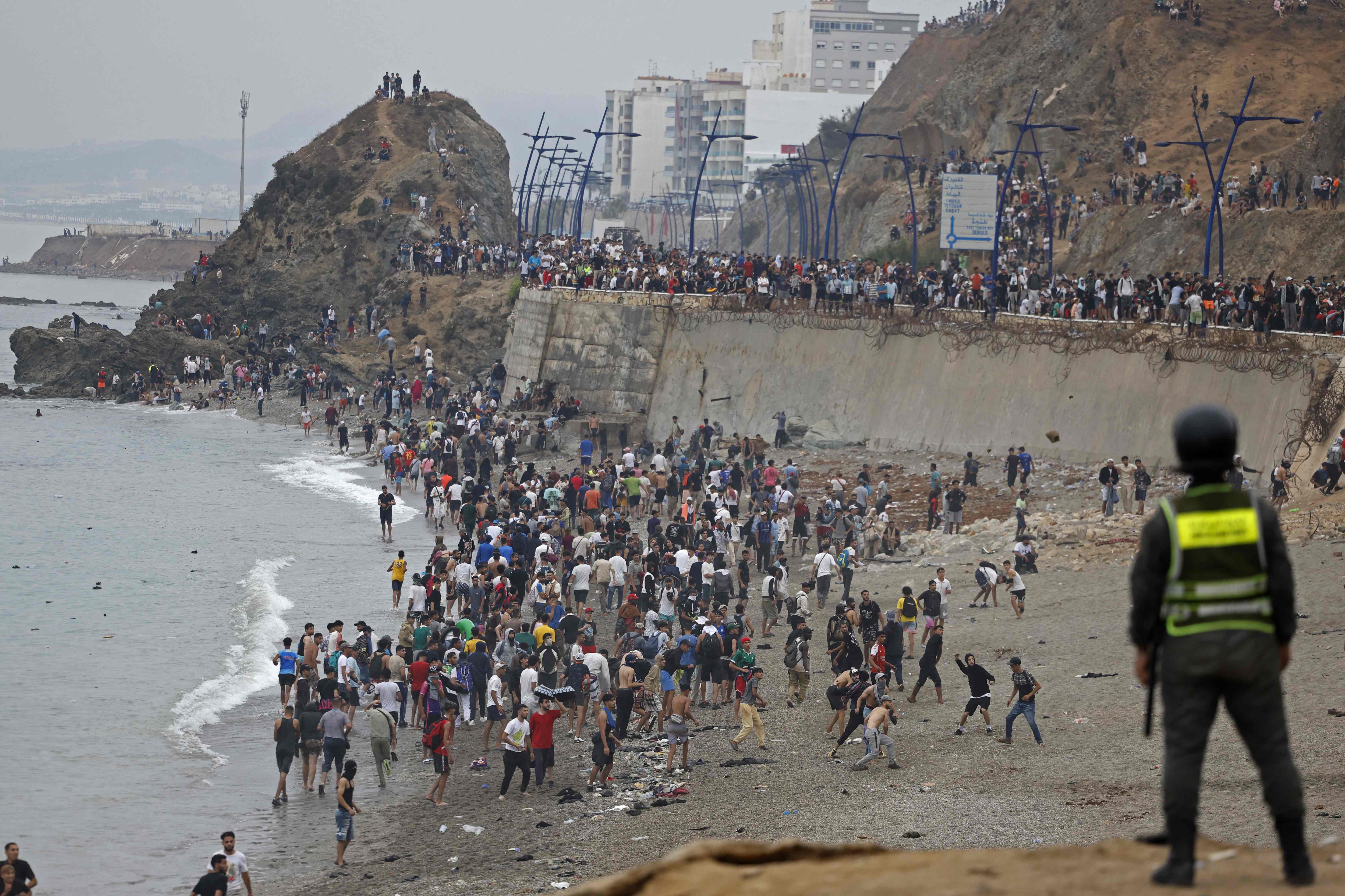 People gather along the fence at the site of clashes near Fnideq, on the Morocco-Spain border. (AFP) People gather along the fence at the site of clashes near Fnideq, on the Morocco-Spain border. (AFP)