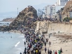 People walk on a beach after attempting to cross from the Moroccan northern town of Fnideq to the Spanish enclave of Ceuta.