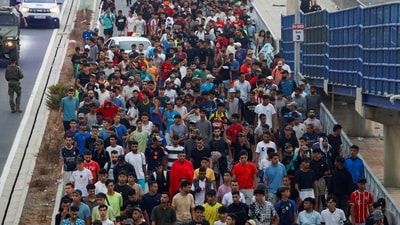Police officers and Spanish soldiers escort a big group of migrants to the border to take them out of Spain, after mass crossings of migrants on foot and by sea from Morocco into Spanish territory, in Ceuta, Spain, August 1, 2026. (REUTERS)