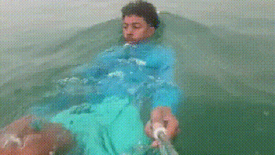 Holding the selfie stick out in front of him, the man recorded his own swim through the water. (Visuals from viral video (Photo Credit: X)) Holding the selfie stick out in front of him, the man recorded his own swim through the water. (Visuals from viral video (Photo Credit: X))