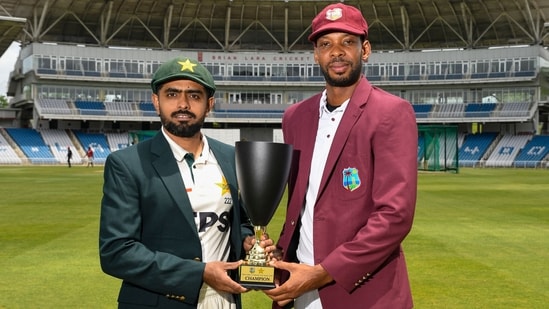 Roston Chase and Babar Azam posing with the trophy.