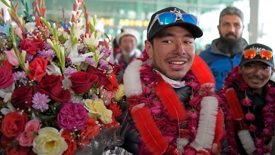 File photo of Nepal's climber Nirmal Purja (C) with his team after becoming the firsts to summit Pakistan's K2 mountain in winter, in Islamabad on January 21, 2021.