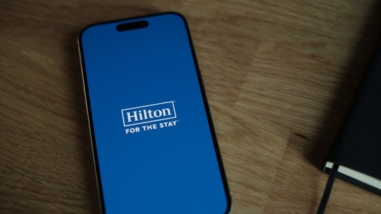 The Hilton app is seen on a phone.