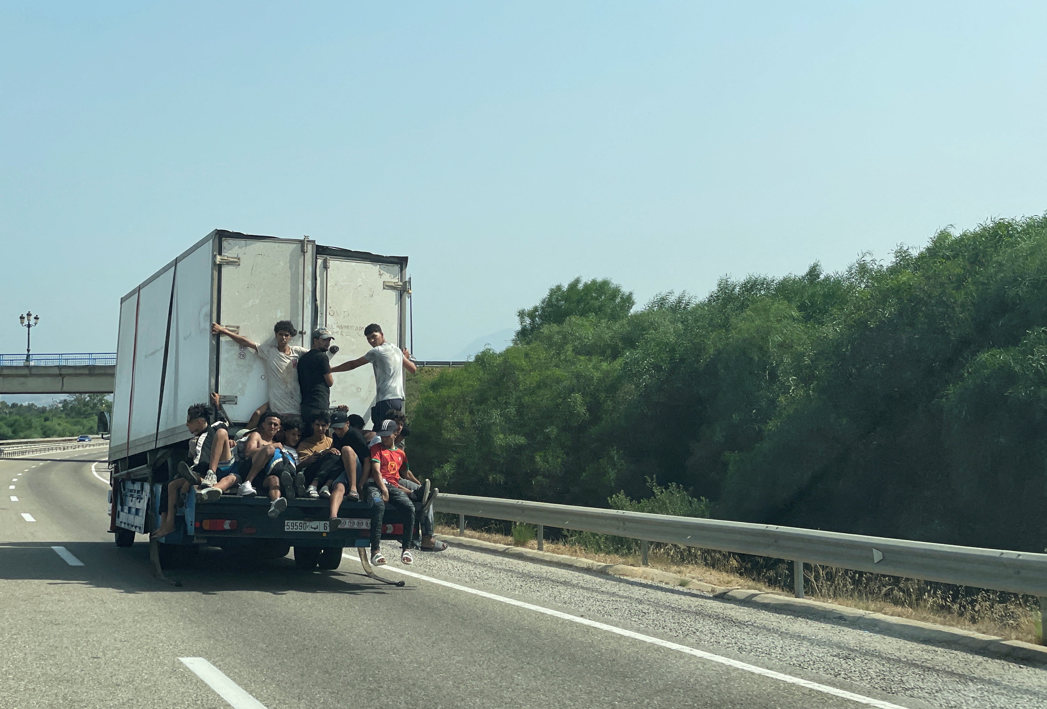 Migrants travel on a truck while waiting for a chance to cross to the Spanish enclave of Ceuta. (File Photo/Reuters)
