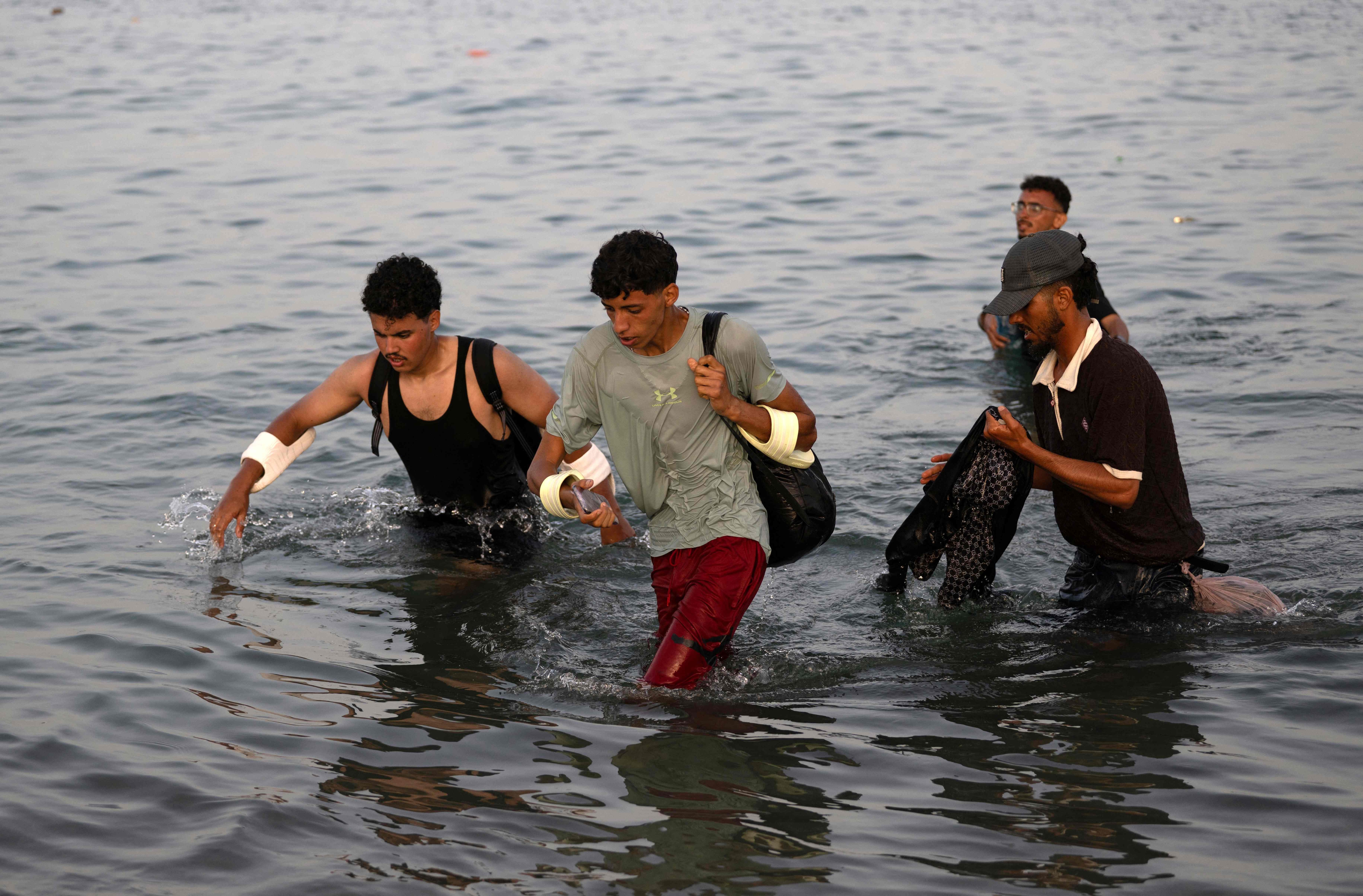 Migrants wade through the water near the border with Morocco as they attempt to enter Spain's North African enclave of Ceuta on July 31, 2026. (File Photo/AFP) Migrants wade through the water near the border with Morocco as they attempt to enter Spain's North African enclave of Ceuta on July 31, 2026. (File Photo/AFP)
