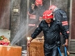 Delhi Fire Service personnel try to douse a fire after it broke out at a paying guest (PG) accommodation, in New Delhi on Wednesday.