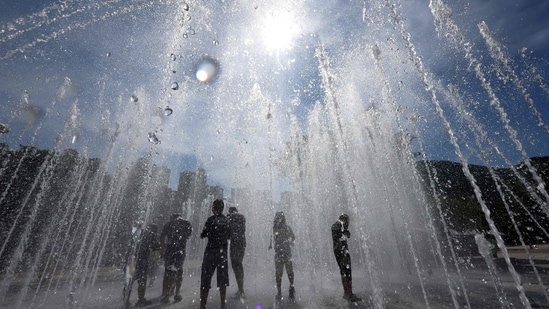 People playing in a fountain to cool off in Yangsan.
