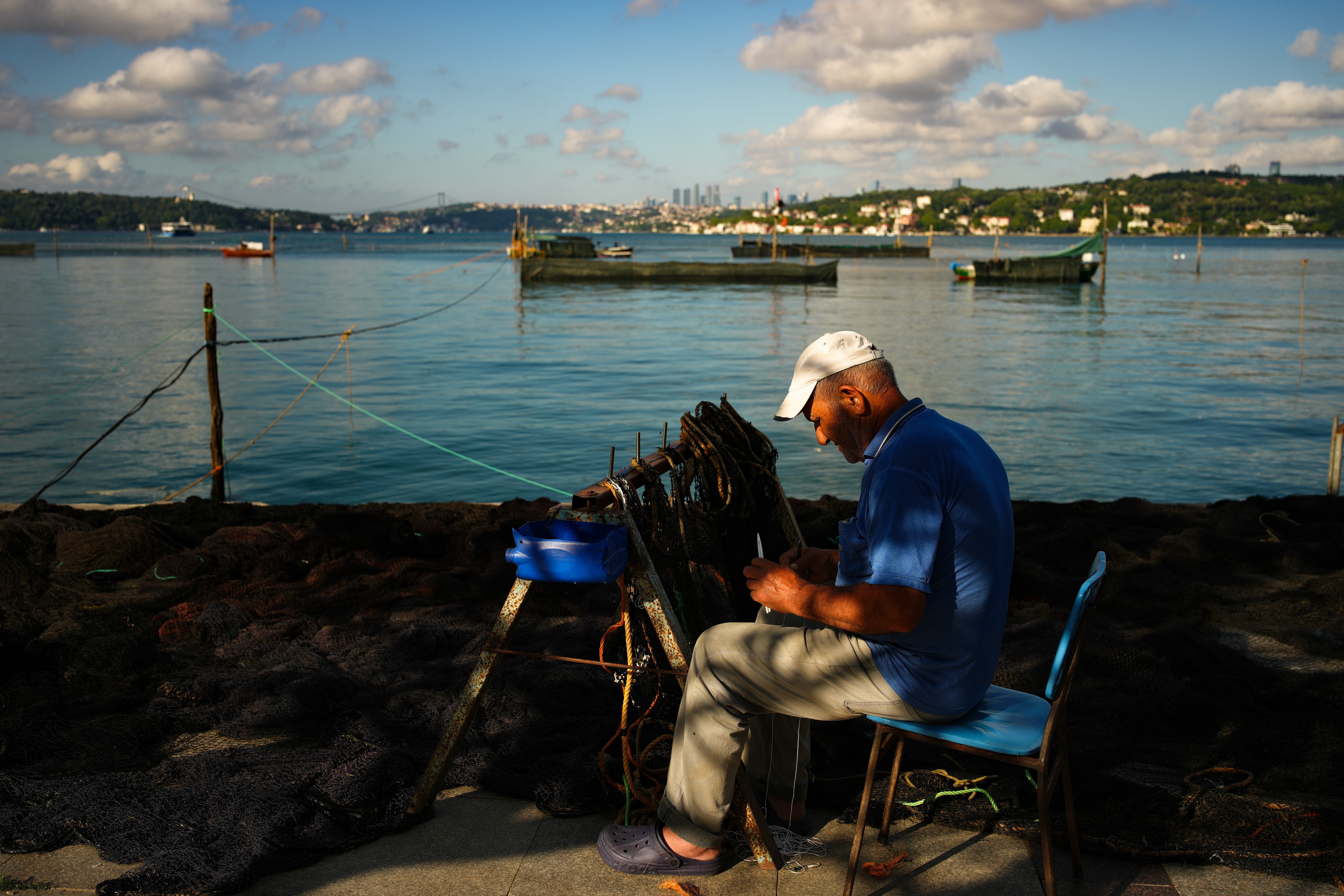 A man repairs a fishing net on the bank of the Bosphorus Strait in Istanbul, Turkey. (AP Photo) A man repairs a fishing net on the bank of the Bosphorus Strait in Istanbul, Turkey. (AP Photo)