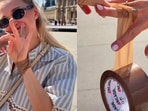 Woman tapes jewellery, phone and bag in Paris.