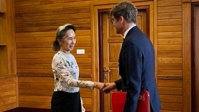 Myanmar's ousted leader Aung San Suu Kyi, shakes hands with Arnaud de Baecque, resident representative of the International Committee of the Red Cross. (Myanmar President Office via AP)