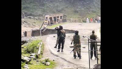 Security personnel stand guard near a damaged bridge after a cloudburst triggered flash floods in the Batkoot area of Pahalgam, in Anantnag district on Monday. (PTI) Security personnel stand guard near a damaged bridge after a cloudburst triggered flash floods in the Batkoot area of Pahalgam, in Anantnag district on Monday. (PTI)