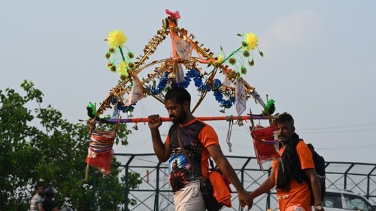 Kanwariyas, devotees of the God Shiva, carry holy water of the river Ganges during the 'Kanwar Yatra' pilgrimage in the sacred month of Sawan (Sanjeev Verma/Hindustan Times)