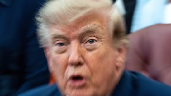 A zoom lens and slow shutter speed technique shows President Donald Trump speaking in the Oval Office of the White House, Monday, Aug. 3.