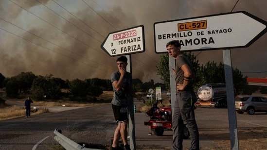 Locals watch the fire near Formariz during a wildfire in Zamora province, Spain