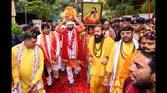 Haryana Chief Minister Nayab Singh Saini carries the sacred kalash containing soil from the birthplace of Guru Ravidas during the Kalash Vandan Yatra, in Gurugram, on Tuesday. (PTI)