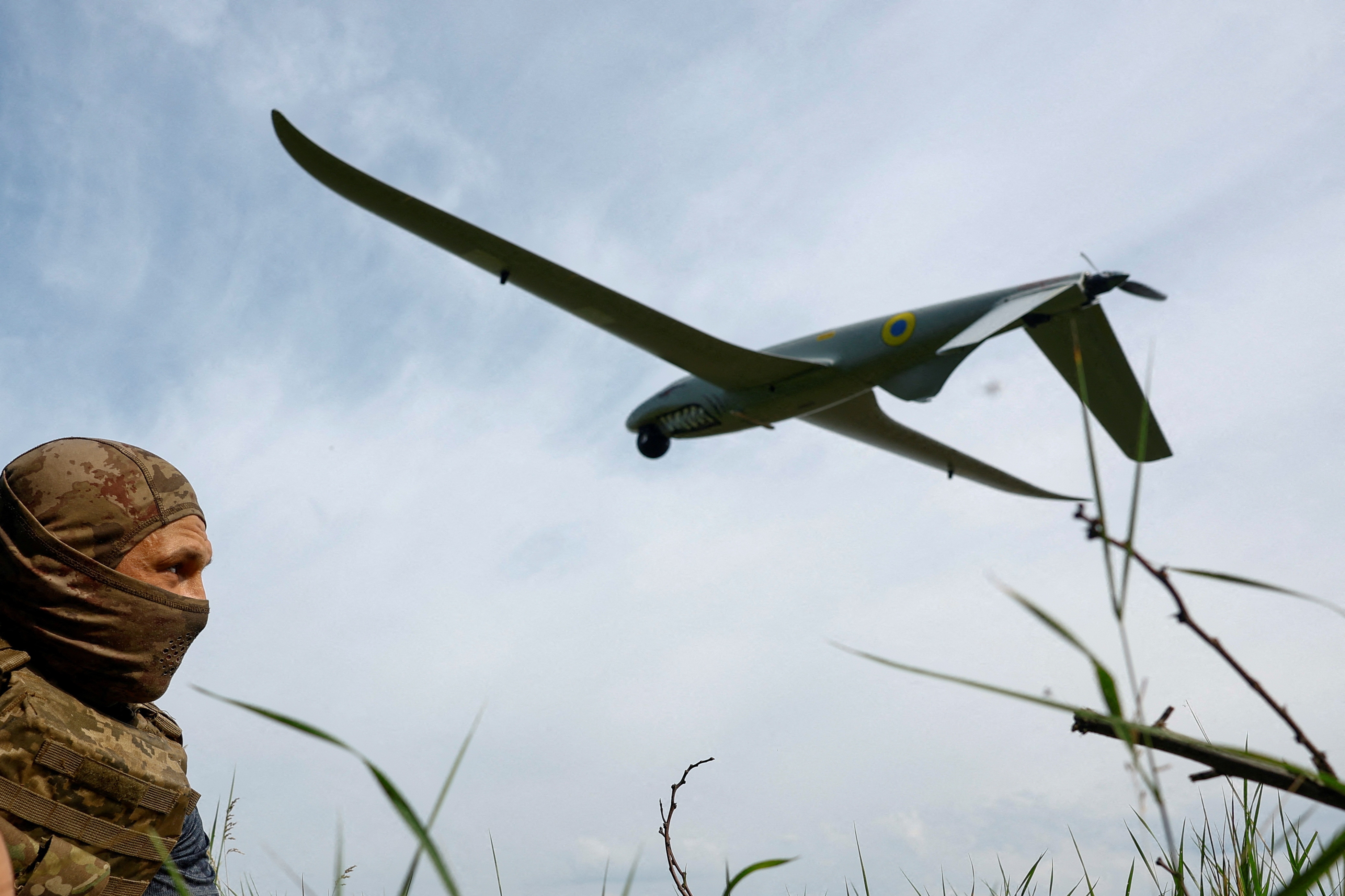 A service member of the 422nd Unmanned Systems Regiment 'Luftwaffe' of the Ukrainian Armed Forces, looks at a Shark reconnaissance drone as it launches from a position near a front line, amid Russia's attack on Ukraine, in an undisclosed location in Southern Ukraine. (REUTERS)