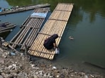 A woman collects water in a jerry can on the shores of a shrinking lake near Somang village in Lebak in Indonesia's western Banten province on July 30, 2026, after it re-emerged from the waters due to the El Nino-driven drought. 