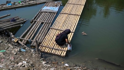 A woman collects water in a jerry can on the shores of a shrinking lake near Somang village in Lebak in Indonesia's western Banten province on July 30, 2026, after it re-emerged from the waters due to the El Nino-driven drought. (AFP) A woman collects water in a jerry can on the shores of a shrinking lake near Somang village in Lebak in Indonesia's western Banten province on July 30, 2026, after it re-emerged from the waters due to the El Nino-driven drought. (AFP)