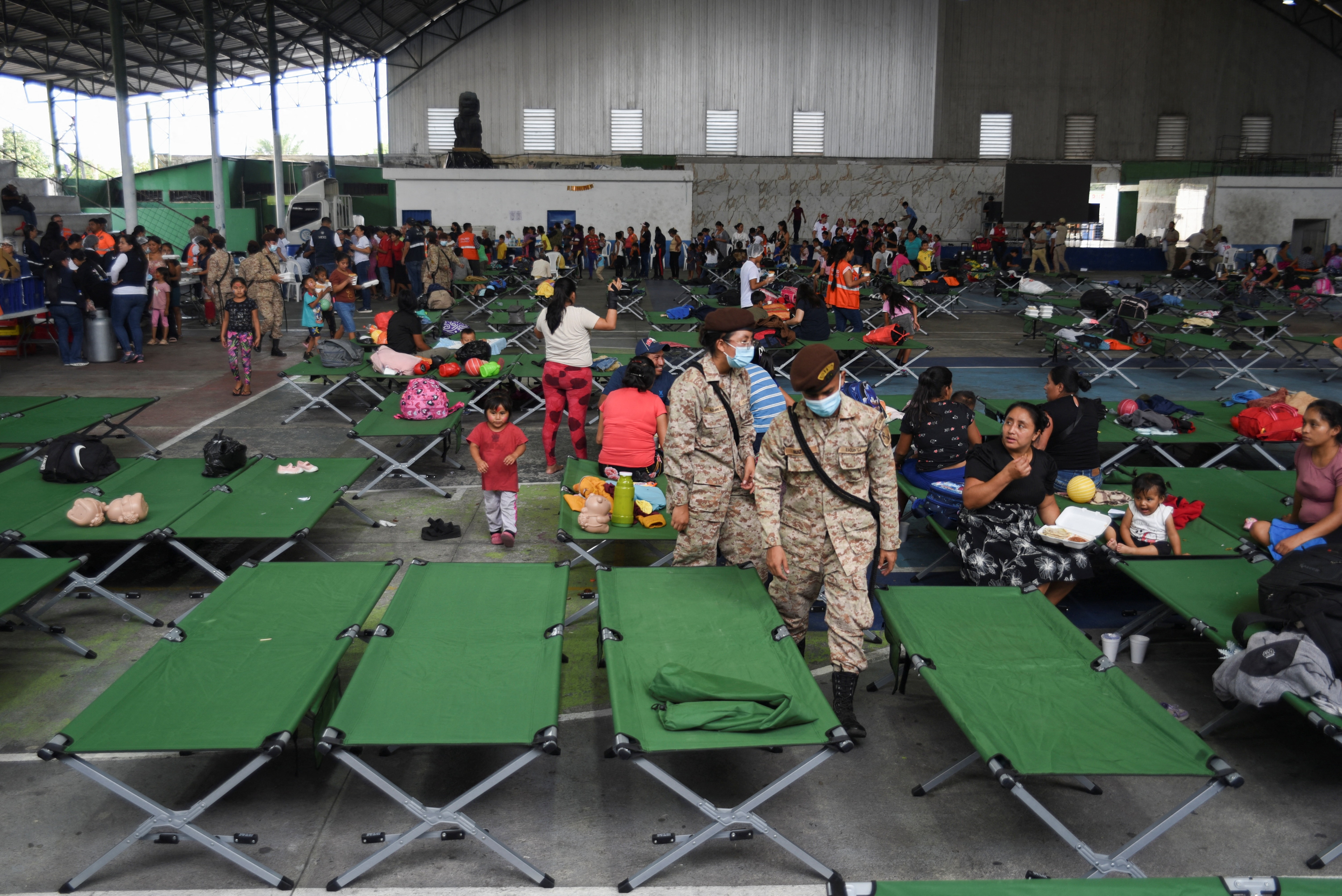 People gather at the Municipal Sports Center, a temporary shelter set up after authorities raised the alert level due to increased activity at Guatemala's Fuego volcano, in Santa Lucia Cotzumalguapa (REUTERS)