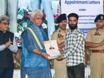 Jammu and Kashmir lieutenant governor Manoj Sinha hands over appointment letters for government jobs to the family members of terror victims at SKICC, in Srinagar on Wednesday. (ANI)