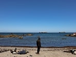 A migrant prays and other rest while waiting on the beach following mass crossings of migrants on foot and by sea from Morocco into Spanish territory, in Ceuta, Spain, August 4, 2026.