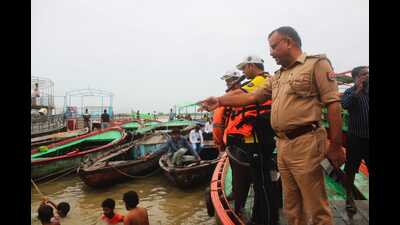 Water police instructing the devotees not to go into deep waters as the water levels of Ganga have been rising (HT) Water police instructing the devotees not to go into deep waters as the water levels of Ganga have been rising (HT)