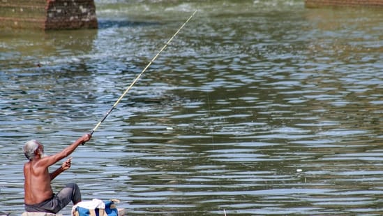 New Delhi, Jul 23 (ANI): A fisherman is fishing at Wazirabad's Yamuna River, in New Delhi on Wednesday. (ANI Photo)