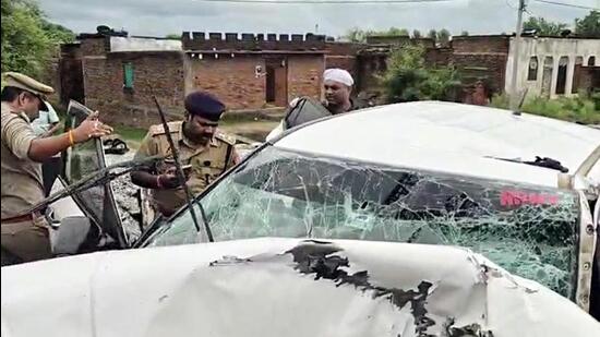 Police personnel inspect the mangled remains of the vehicle at the site of the accident Jhansi on Thursday. (ANI VIDEO GRAB)