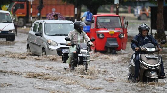 Vehicles wade through a waterlogged stretch following heavy rain in Gurugram on Thursday. (Parveen Kumar/ HT Photo)