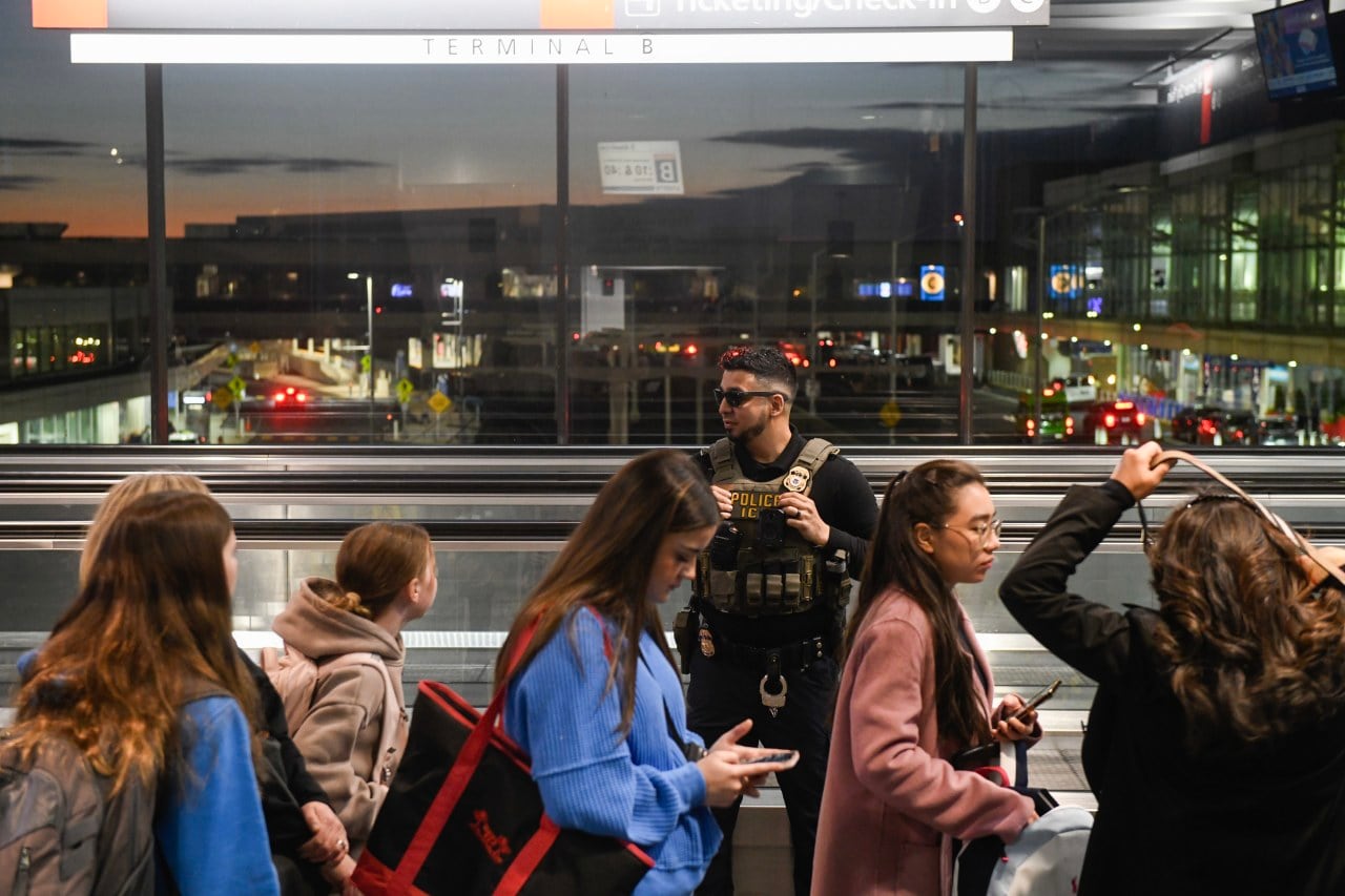An ICE agent posted near a moving walkway monitored travelers at Philadelphia International Airport earlier this year. An ICE agent posted near a moving walkway monitored travelers at Philadelphia International Airport earlier this year.