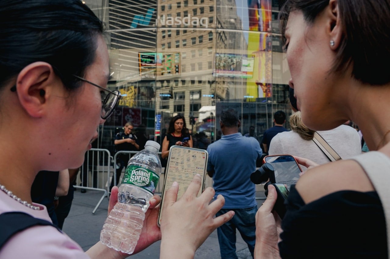 Bystanders outside Nasdaq in Times Square watched the share price. Bystanders outside Nasdaq in Times Square watched the share price.