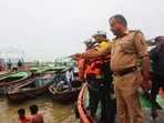 Water police instructing the devotees not to go into deep waters as the water levels of Ganga have been rising (HT)