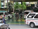 Armed police walk through the school campus in Nonthaburi, Thailand, where a mass shooting took place Friday.