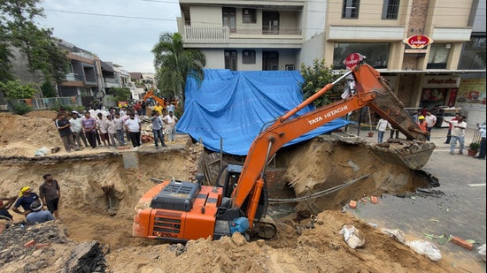 MC workers repair work on road cave-in, in Kitchlu Nagar area Ludhiana on Friday. (Gurpreet Singh/HT)